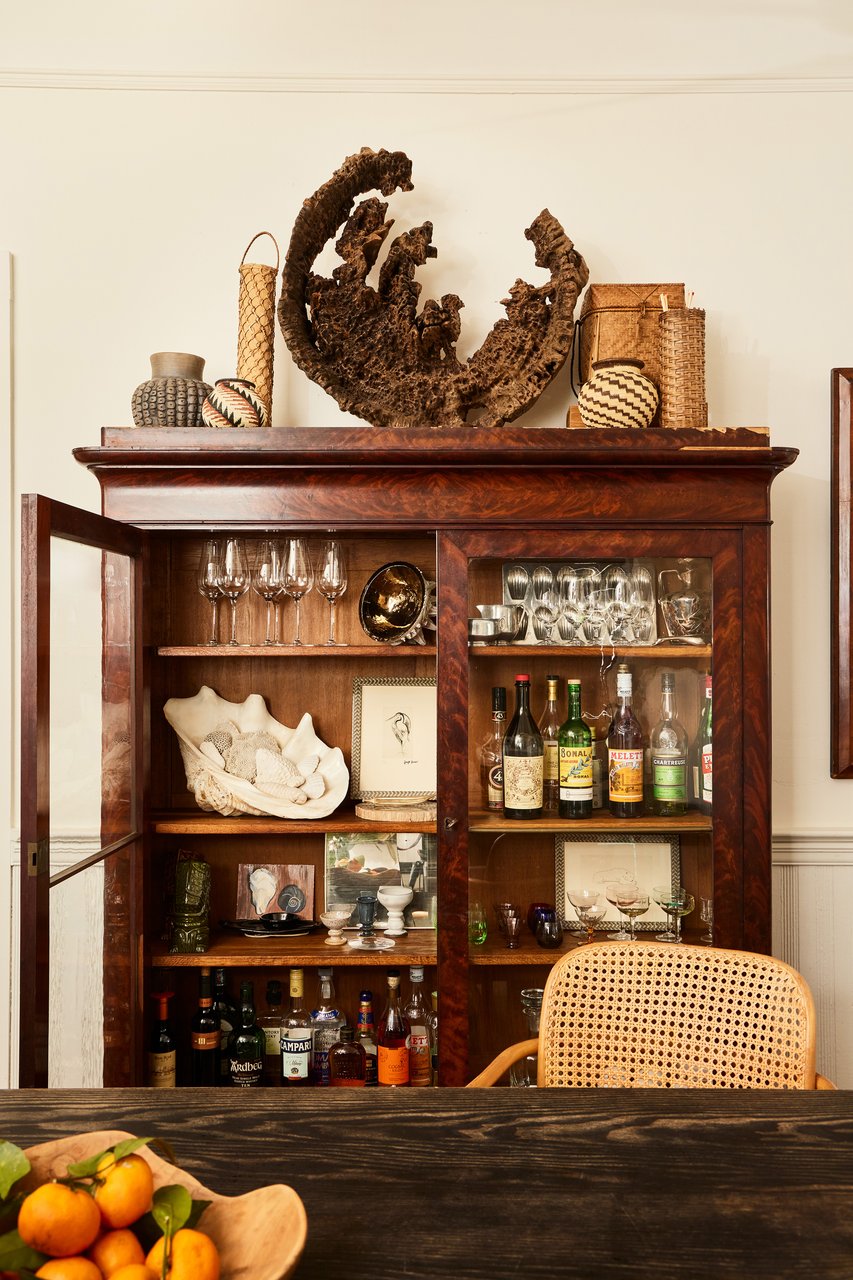 Dining Room vignette. Driftwood, bottles, oranges, wicker.
